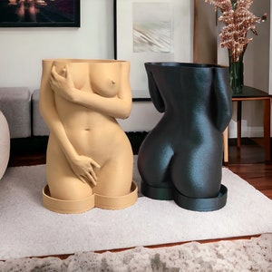 K&ouml;nnte beinhalten: Zwei Pflanzgef&auml;&szlig;e in Form eines menschlichen Torsos. Eines ist in einem Nackt-Beige gehalten, das andere in Dunkelblau.