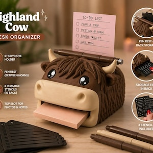 May include: A brown Highland cow desk organizer featuring a top slot for a pink to-do list, a pen rest between the horns, and a rear storage tray. The set includes three black reusable stencils and a brown pen. The organizer has a textured finish.