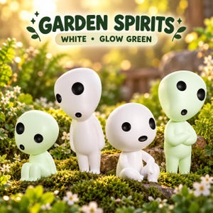 May include: Four small, smooth, humanoid figurines with large round heads and black oval eyes. Two are white and two are pale green. The text GARDEN SPIRITS WHITE • GLOW GREEN is displayed above the figures in a dark green font.