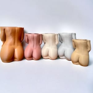 K&ouml;nnte beinhalten: F&uuml;nf Keramik-Blument&ouml;pfe in Form des menschlichen K&ouml;rpers in verschiedenen Braunt&ouml;nen, Rosa, Beige und Wei&szlig;.