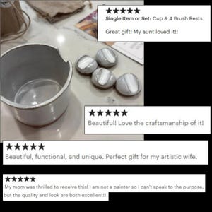 May include: A ceramic cup and four brush rests. The cup is white with a slightly textured surface and a rounded shape. The brush rests are oval-shaped, with a white and gray color scheme. The image includes customer reviews.