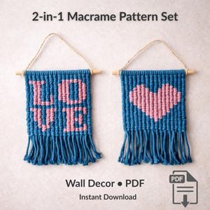 Könnte beinhalten: Zwei blaue Makramee-Wandbehänge mit Fransen, eines mit der Aufschrift "LOVE" in Rosa und das andere mit einem rosa Herzen. Das Set enthält ein PDF-Muster zum sofortigen Download. Der Text "2-in-1 Makramee-Musterset" steht oben.