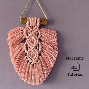 Delicate macrame wall hanging in dusty pink, crafted with care — elegant leaf shape, easy to make at home.