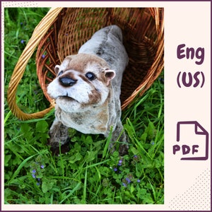 May include: A plush otter toy with brown and gray fur, sitting in a wicker basket. The otter is looking up with a curious expression. The basket is surrounded by green grass and purple flowers.