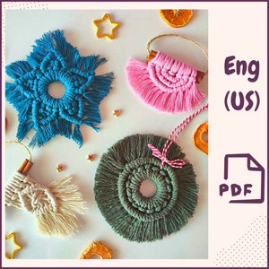 Puede incluir: Una colección de adornos de macramé hechos a mano en varios colores. Los adornos incluyen una estrella azul, un abanico rosa, un diseño circular verde y un diseño color crema. Los adornos están decorados con palitos de canela y detalles en forma de estrella.