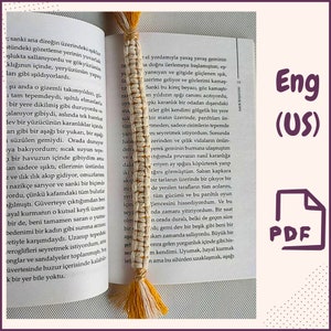 Puede incluir: Un marcapáginas tejido amarillo y blanco con un borla. El marcapáginas está colocado en una página de un libro con texto en un idioma extranjero. El texto en la página dice "sanki ana direğin üzerindeki şar stündeki gözetleme yerinin yuvarlak şlukta sallanıyordu ve gökyüzünün klığının içinde, yeryüzünün yapay ları gibi ışıldıyorlardı."