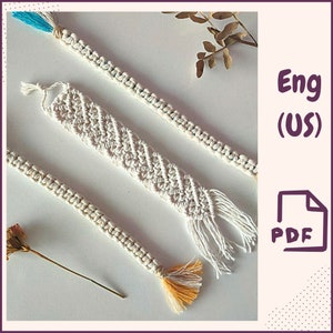 Puede incluir: Tres marcapáginas de cordón macramé con flecos. El marcapáginas de la izquierda tiene un fleco amarillo y naranja. El marcapáginas del centro tiene un fleco blanco. El marcapáginas de la derecha tiene un fleco azul y blanco. La imagen incluye el texto "Eng (US) PDF".