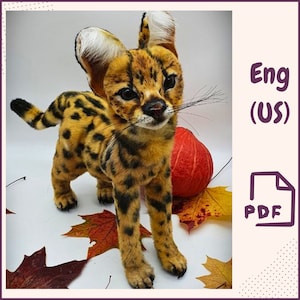 May include: A plush toy of a serval kitten, a wild cat with distinctive large ears and a spotted coat. The kitten is standing on a white surface with autumn leaves and a red pumpkin.