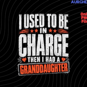 Peut inclure: Graphisme noir avec le texte "I USED TO BE IN CHARGE THEN I HAD A GRANDDAUGHTER" en blanc et orange. Le design comprend des étoiles et un cœur.