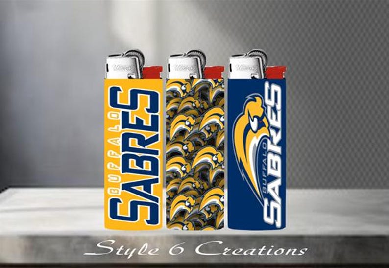 K&ouml;nnte beinhalten: Drei Feuerzeuge mit unterschiedlichen Designs. Eines ist gelb mit "BUFFALO SABRES" in Blau, ein anderes hat ein Muster aus gelben und schwarzen S&auml;bel-Logos, und das dritte ist blau mit dem Teamlogo und "BUFFALO SABRES".