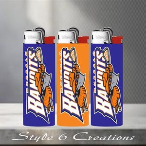 K&ouml;nnte beinhalten: Drei Feuerzeuge mit einem blau-orange-wei&szlig;en Design mit dem Wort "Bandits" und einer Lacrosse-Spieler-Grafik. Die Feuerzeuge haben einen silbernen Deckel und rote Akzente. Der Text "Style 6 Creations" befindet sich unten.