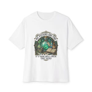 May include: White t-shirt with a graphic featuring potion bottles, a mortar and pestle, and an open book. The text reads "MY POTIONS ARE FINE, IT'S YOUR SKILL CHECK THAT SUCKS."