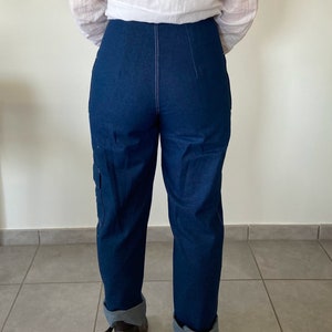 Op de afbeelding: Een donkerblauwe spijkerbroek met een hoge taille en gezoomde pijpen. De broek heeft een rechte pijp en is gemaakt van een dikke, duurzame stof.