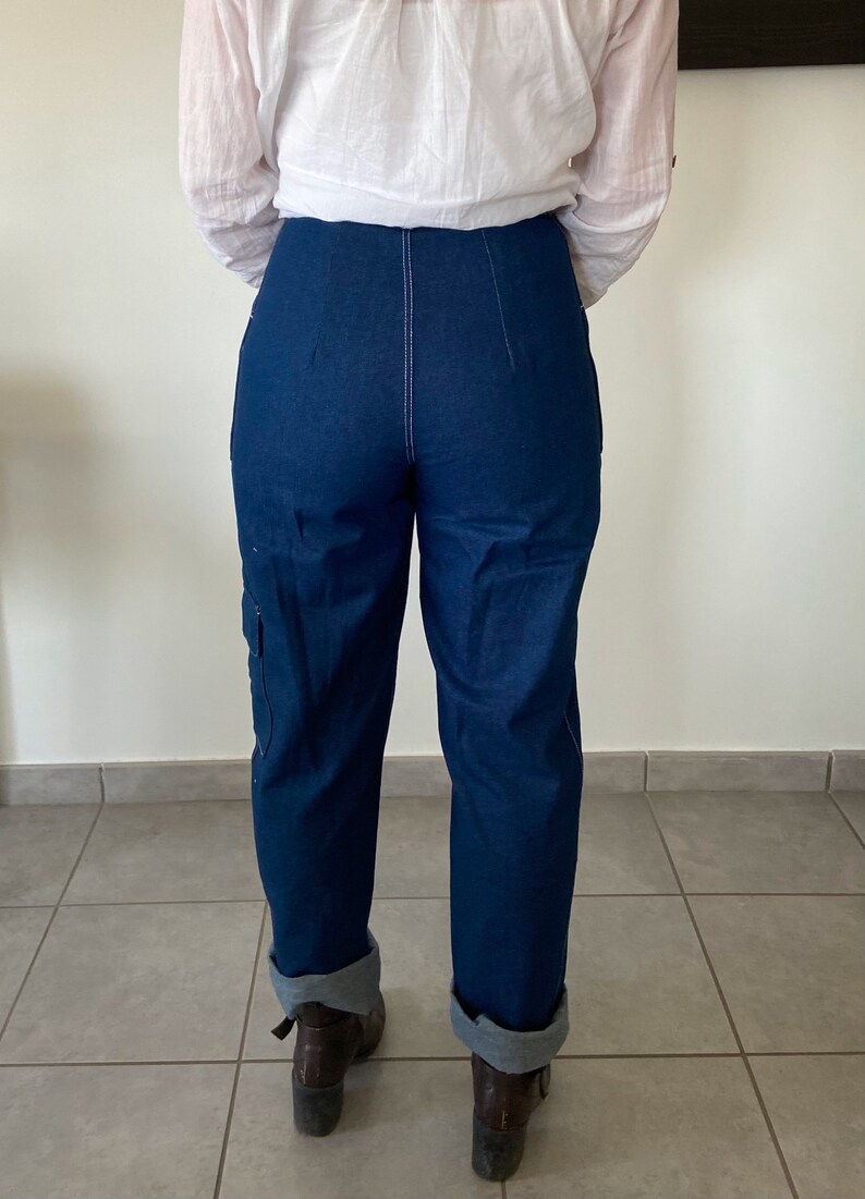 Op de afbeelding: Een donkerblauwe spijkerbroek met een hoge taille en gezoomde pijpen. De broek heeft een rechte pijp en is gemaakt van een dikke, duurzame stof.