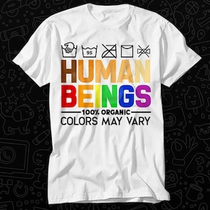 May include: White t-shirt with a rainbow colored graphic that says "HUMAN BEINGS - 100% ORGANIC COLORS MAY VARY". The graphic also includes a set of laundry care instructions.