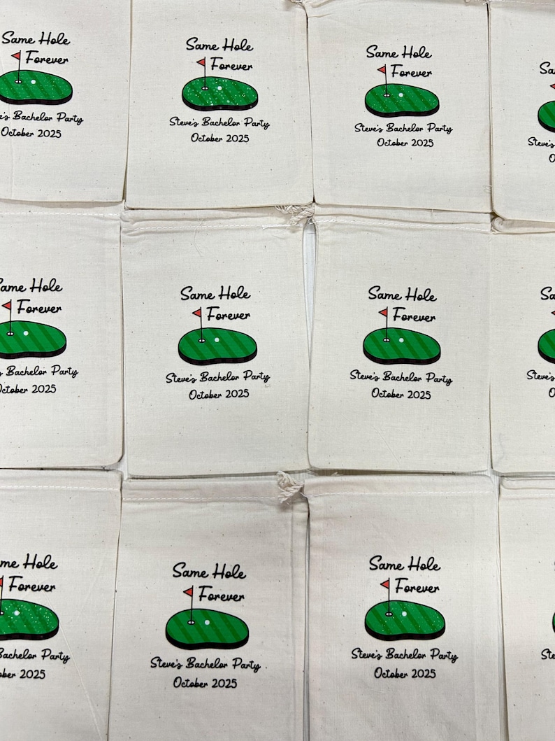 Puede incluir: Bolsas con cord&oacute;n de color crema con un dise&ntilde;o tem&aacute;tico de golf. Cada bolsa presenta una ilustraci&oacute;n de un campo de golf verde con una bandera roja y el texto "Same Hole Forever". Debajo del gr&aacute;fico est&aacute; el texto "Steve's Bachelor Party October 2025."