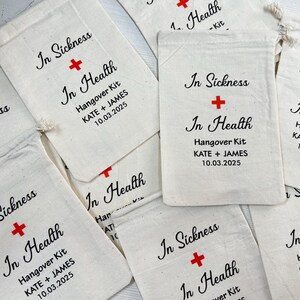 Puede incluir: Una colecci&oacute;n de bolsas de lona blanquecina con el texto "In Sickness + In Health" y una cruz roja. Cada bolsa est&aacute; etiquetada como "Hangover Kit" e incluye los nombres "KATE + JAMES" y la fecha "10.03.2025".