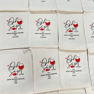 Puede incluir: Bolsas de lona de color blanquecino con un dise&ntilde;o de copa de vino tinto y labios, con las palabras "Oh Sip!" y "It's Sippin' Sisters Takeover 2025" impresas en negro y rojo. Algunas bolsas tienen nombres impresos debajo.