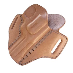 May include: A light brown leather holster with black stitching. The holster has a molded shape with a curved design and several openings. The edges are reinforced with stitching.