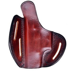 Op de afbeelding: Een bruine leren holster met stiksels en uitsparingen.
