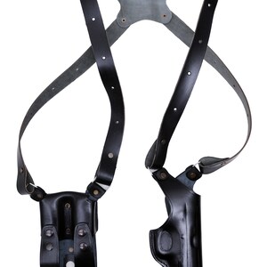 May include: Black leather shoulder holster with two holsters for carrying handguns. The holster has adjustable straps and is designed for concealed carry.