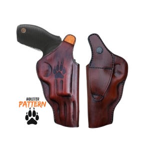 Op de afbeelding: Een bruin leren holster met een pootafdrukontwerp en een zwarte revolver. De holster wordt in twee delen getoond, met de tekst "HOLSTER PATTERN" en een pootafdruk-afbeelding.