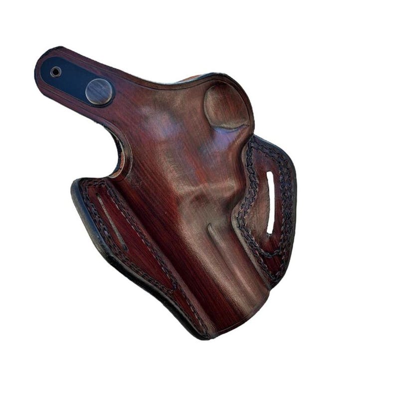 Peut inclure: Un &eacute;tui en cuir marron avec un motif cousu et un bouton en m&eacute;tal. L'&eacute;tui est con&ccedil;u pour contenir une arme &agrave; feu.