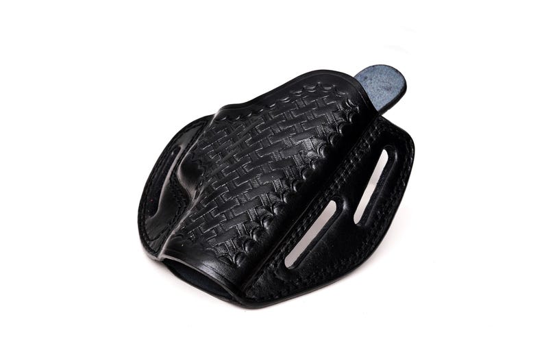 Op de afbeelding: Zwarte leren holster met een geweven patroon. De holster heeft een riemlus en een drukknopsluiting.