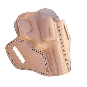 May include: A light tan leather holster with a molded design. The holster features a stitched border with black thread and a cutout for a belt clip. The leather has a natural, unpainted finish.