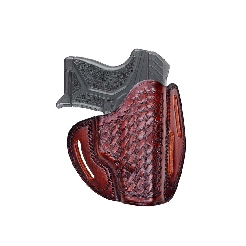 Op de afbeelding: Een bruine leren holster met een geweven patroon, ontworpen om een ​​zwart pistool te houden. De holster heeft een riemlus en een trekkerbescherming.