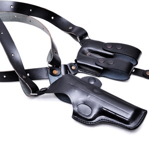 May include: A black leather shoulder holster for a handgun. The holster has adjustable straps and a magazine pouch.