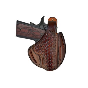 Peut inclure: Un étui en cuir marron avec un motif tissé, conçu pour contenir une arme à feu. L'étui a une boucle de ceinture et une protection de la gâchette.