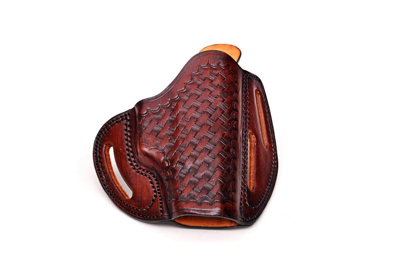 Op de afbeelding: Een bruine leren holster met een geweven patroon. De holster heeft een riemlus en een trekkerbescherming.