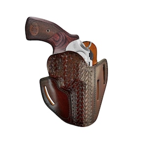 May include: A brown leather holster with a woven pattern, designed to hold a silver revolver with a wooden grip.