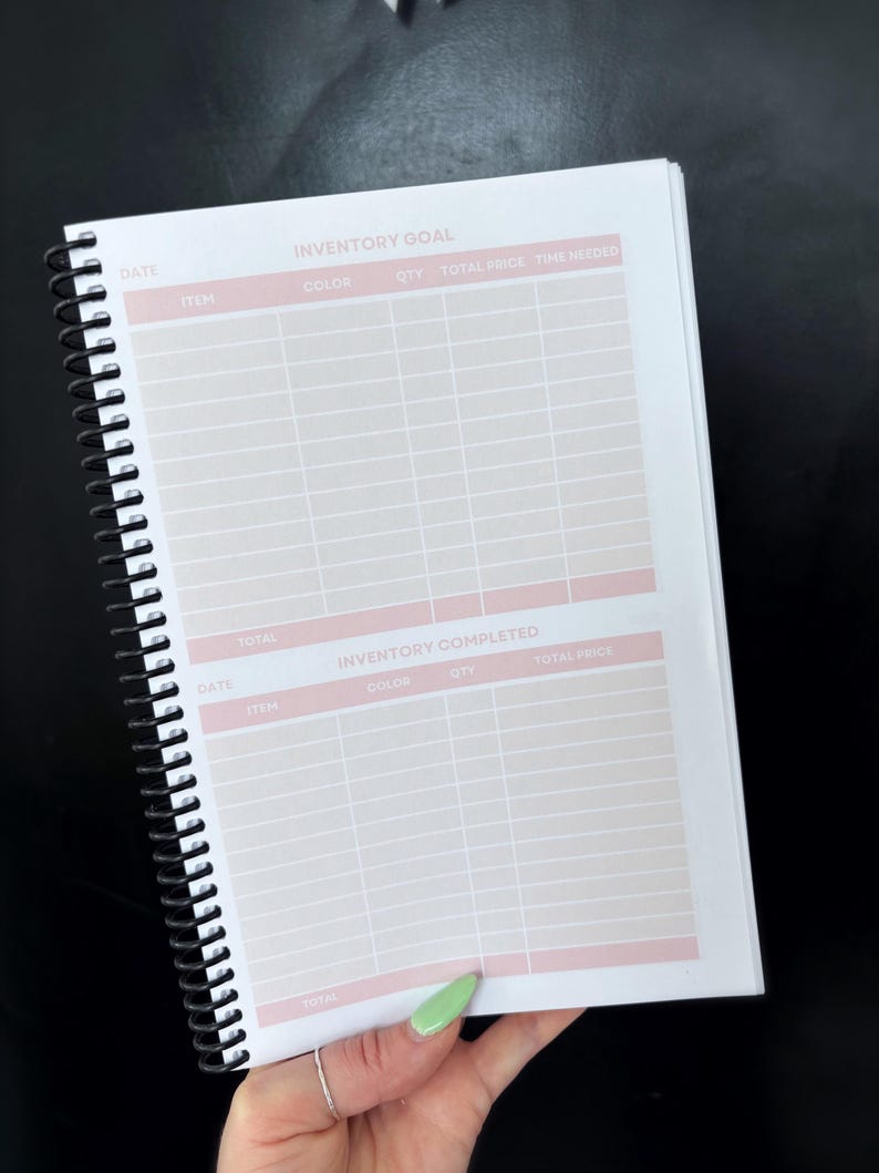 May include: A spiral bound notebook with a pink and white gridded page. The page is labeled "Inventory Goal" and "Inventory Completed". The notebook is used for tracking inventory.