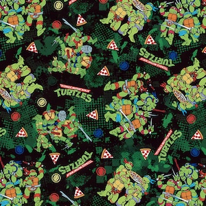 May include: A black fabric pattern featuring Teenage Mutant Ninja Turtles characters in various action poses, holding swords and nunchucks, interspersed with pizza slices and the Teenage Mutant Ninja Turtles logo in green and red text.