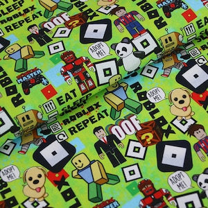 Könnte beinhalten: Grüner Stoff mit einem sich wiederholenden Muster aus Roblox-Charakteren, Logos und Text. Der Text enthält "Roblox", "Adoptiere mich!" und "Iss Schlaf Roblox Wiederhole".
