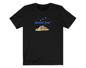 Op de afbeelding: Zwart T-shirt met een blauwe afbeelding van piramides en sterren met de tekst "Ancient Soul" in blauw.