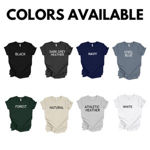 Peut inclure: Image pr&eacute;sentant huit t-shirts de diff&eacute;rentes couleurs : noir, gris fonc&eacute; chin&eacute;, marine, bleu acier, vert for&ecirc;t, naturel, chin&eacute; athl&eacute;tique et blanc. Le texte "COLORS AVAILABLE" est en haut.