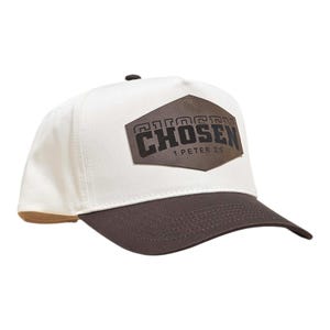 Peut inclure: Casquette de baseball blanche et marron avec le mot "CHOSEN" sur un patch marron foncé texturé. Le texte "1 PETER 2:9" est en dessous. La casquette a une visière incurvée et un bouton sur le dessus.