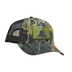 May include: Camouflage baseball cap with a black mesh back. The front features a green patch with a coiled snake and the text "DON'T TREAD ON ME". The cap has a curved brim and a button on top.