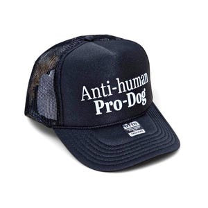 May include: A navy blue trucker hat with the text "Anti-human Pro-Dog" in white. The hat features a mesh back and a structured front panel. The brim is curved, and the hat has an adjustable strap.