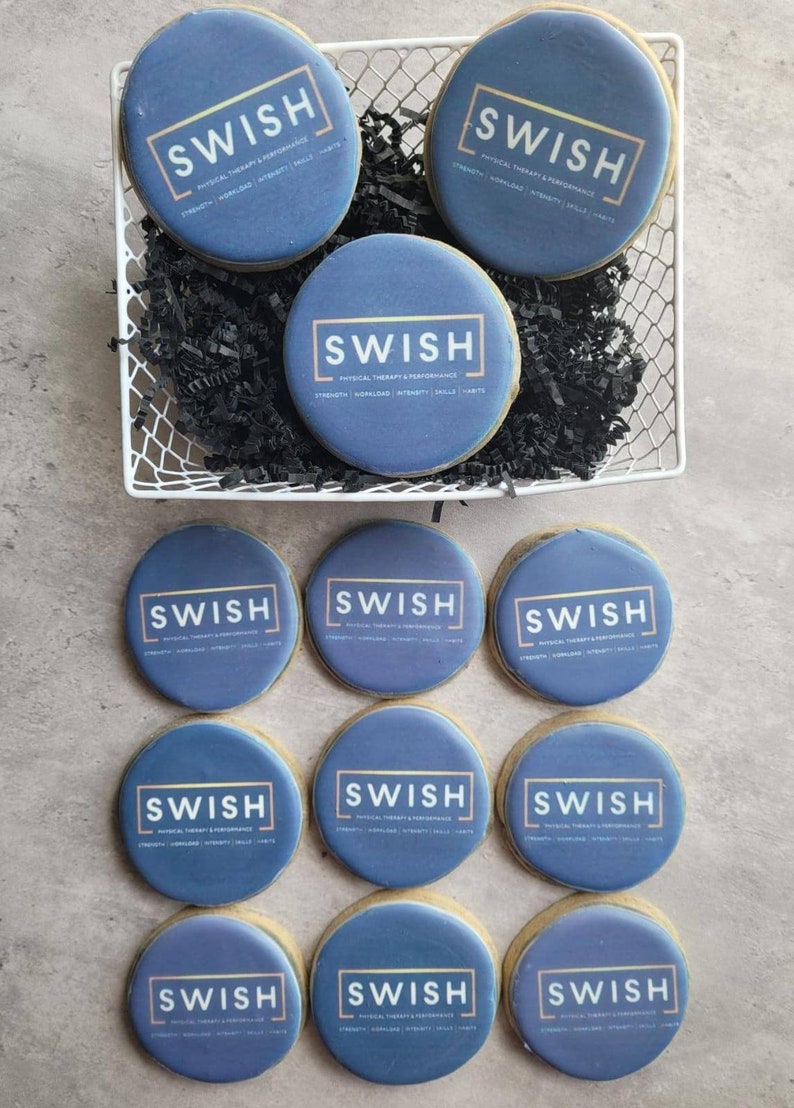 May include: A dozen round blue cookies with gold lettering that reads "SWISH PHYSICAL THERAPY & PERFORMANCE" in a white box with black shredded paper.