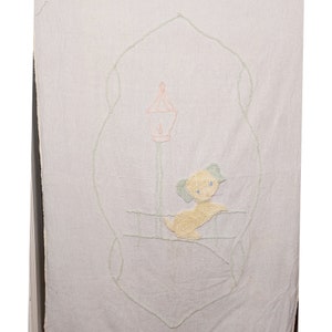 May include: A white embroidered baby blanket with a light green border and a yellow dog with blue eyes sitting under a pink and green lamppost.