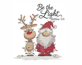 May include: An embroidered design featuring a tan reindeer and a Santa Claus figure, both wrapped in colorful Christmas string lights. Above them, the text reads Be the Light Matthew 5:14 in a black script and serif font combination.