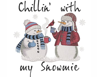 Puede incluir: Dos muñecos de nieve, uno con un sombrero y una chaqueta rojos, el otro con un sombrero y una bufanda azules, sostienen tazas de chocolate caliente. Un cardenal rojo se sienta en la mano del muñeco de nieve, sosteniendo una taza. El texto "Chillin' with my snowmie" está escrito debajo de los muñecos de nieve.