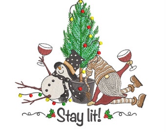 Puede incluir: Un muñeco de nieve y un gnomo sostienen vasos de vino y se apoyan en un pequeño árbol de Navidad con luces rojas y amarillas. El texto "Stay lit!" está debajo de la imagen.