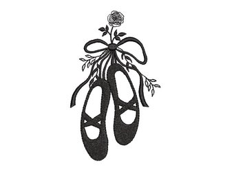 May include: A pair of black ballet shoes tied together with a ribbon and a small white flower.