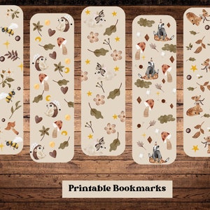 Può includere: Set di cinque segnalibri stampabili con illustrazioni di animali del bosco. I segnalibri hanno uno sfondo beige con varie creature del bosco, funghi, foglie e stelle. Il testo "Segnalibri stampabili" è in fondo all'immagine.