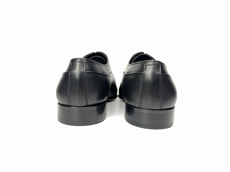 May include: A pair of black leather lace-up shoes with a classic design. The shoes have a rounded toe and a low heel.